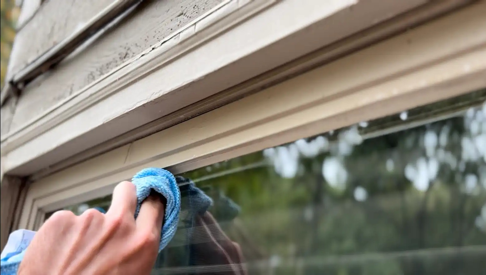 Window track being cleaned with a detail brush and vacuum